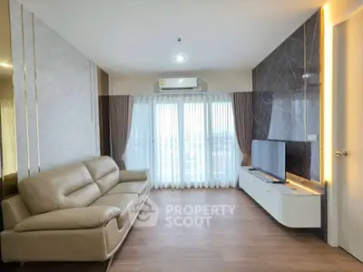 Modern living room with sleek design, featuring a comfortable sofa and large TV, perfect for relaxation.