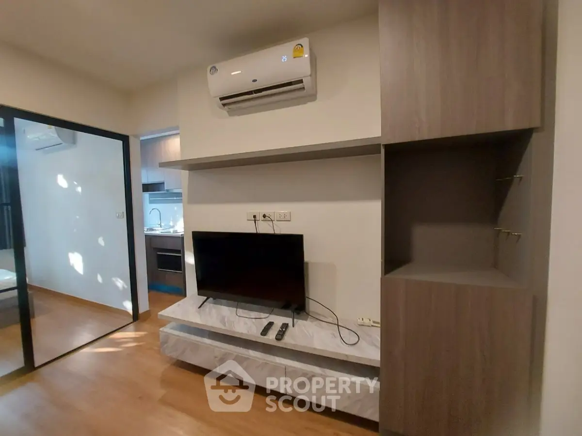 Modern living room with built-in TV unit and air conditioning in a stylish apartment.
