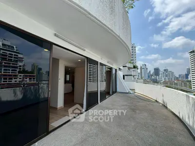 Spacious balcony with stunning city skyline views in modern high-rise apartment.