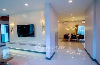 Spacious modern living room with elegant dining area, featuring sleek lighting and contemporary decor.