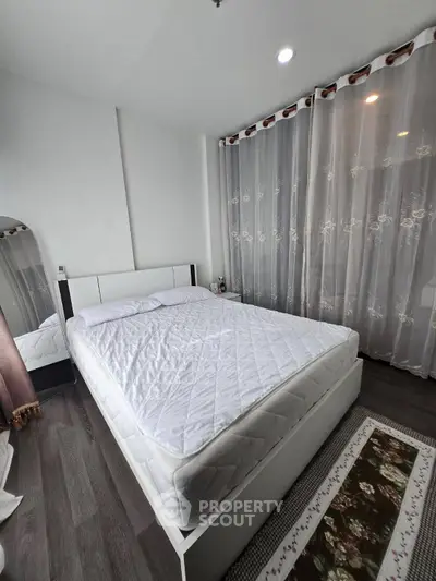 Cozy bedroom with elegant curtains and modern decor, perfect for relaxation and comfort.