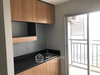 Modern kitchen with sleek cabinetry and balcony view in urban apartment