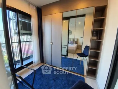 Modern bedroom with mirrored wardrobe and balcony view in urban apartment