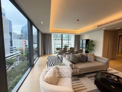 Luxurious living room with panoramic city views and modern decor in a high-rise apartment.