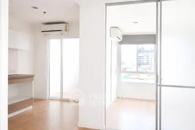 Bright modern apartment interior with sliding glass doors and air conditioning, featuring sleek wooden flooring.