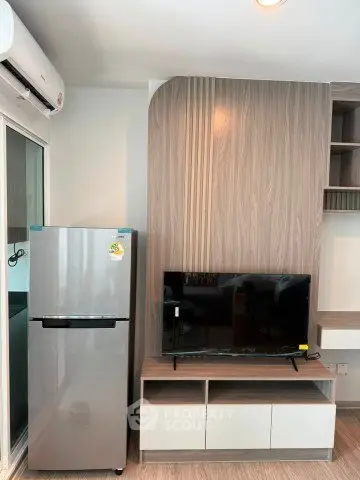 Modern living room with sleek TV unit and stainless steel fridge, perfect for contemporary urban living.
