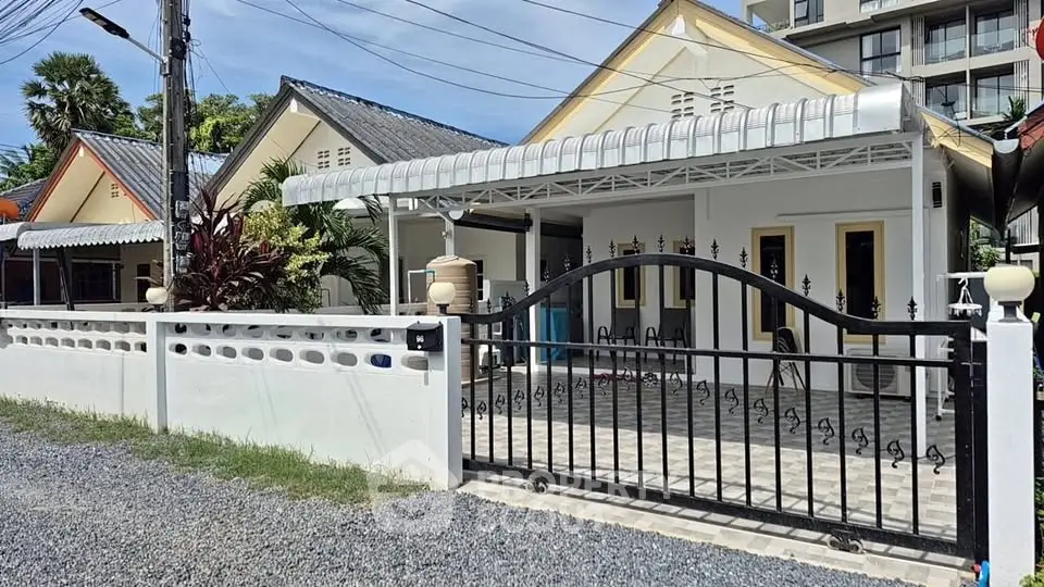 Charming single-story house with gated entrance and spacious driveway in a serene neighborhood.