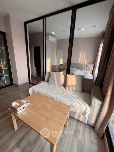 Modern living room with cozy sofa and wooden table, featuring a stylish glass partition.
