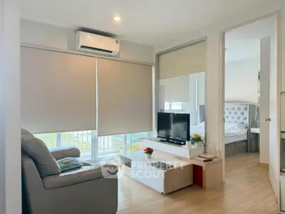 Modern living room with cozy seating and natural light in a stylish apartment.