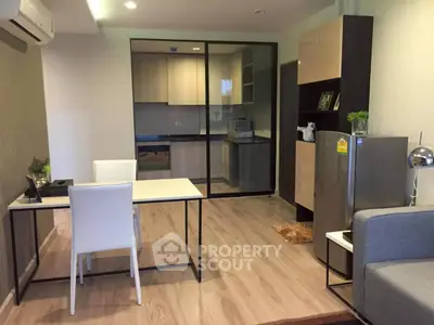 Modern open-plan living room with sleek kitchen and stylish decor in a contemporary apartment.