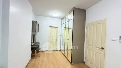 Spacious bedroom with mirrored wardrobe and wooden flooring
