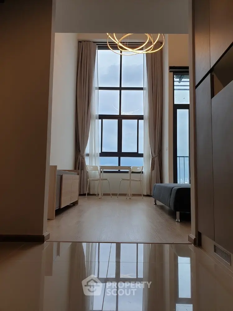 Modern apartment interior with high ceiling and large windows offering stunning views.
