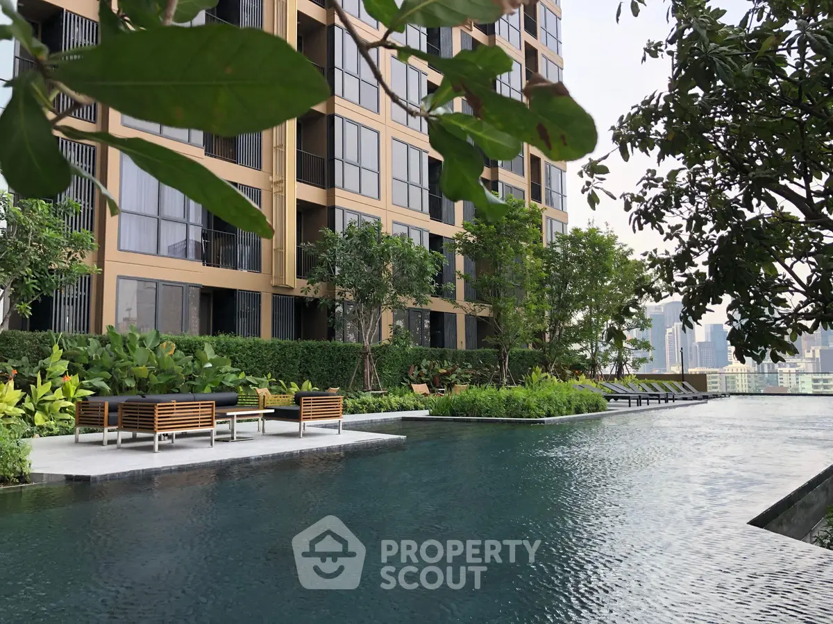 Luxurious apartment building with serene pool and lush greenery, offering a tranquil urban oasis.