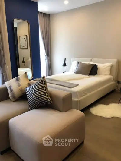 Modern bedroom with stylish decor and cozy seating area, perfect for relaxation and comfort.