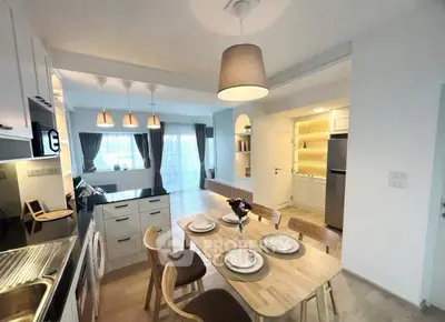 Modern open-layout kitchen and dining area with elegant lighting and stylish decor.