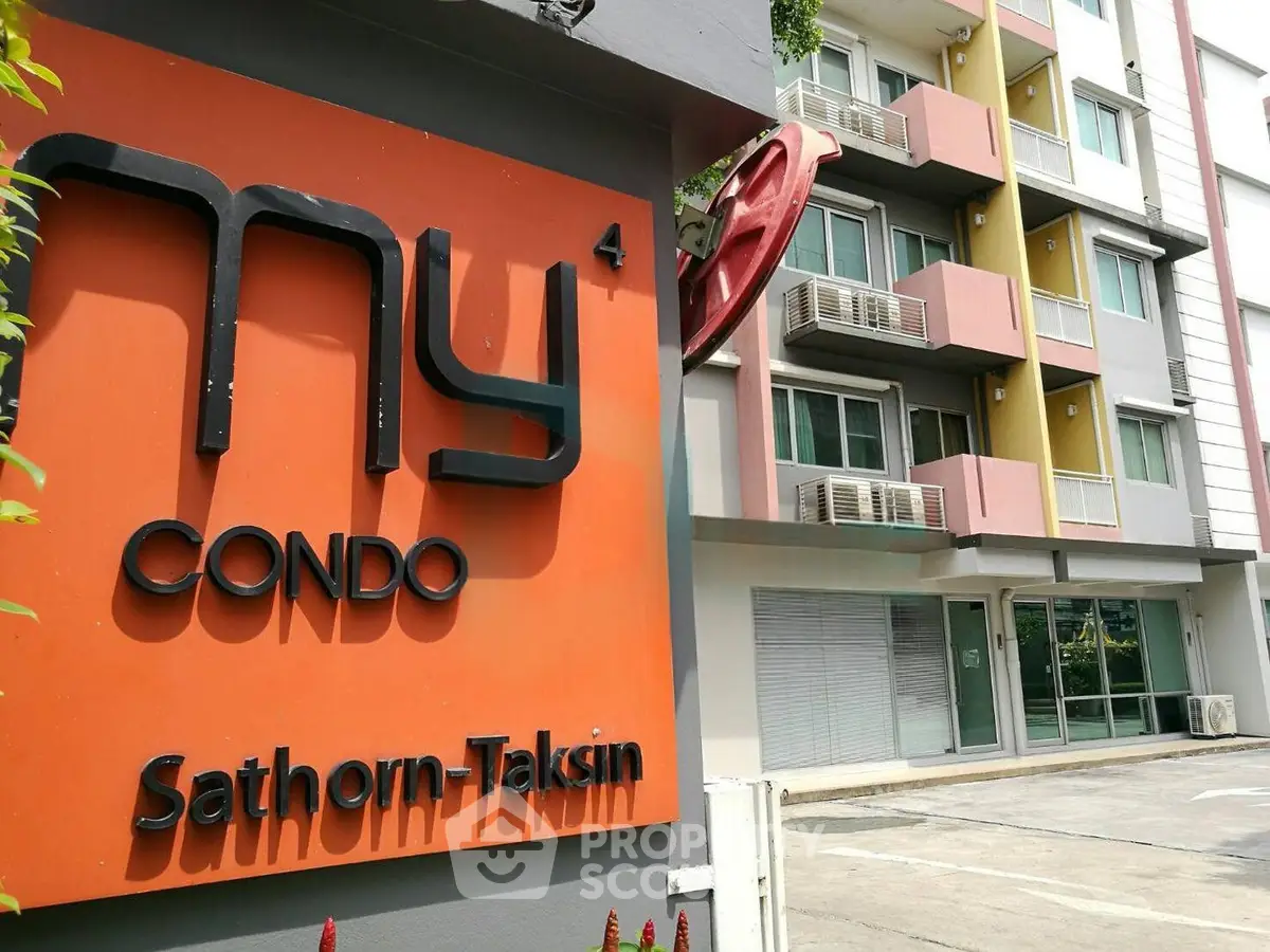 Modern condo building exterior with colorful balconies and signage at Sathorn-Taksin.