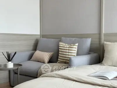 Cozy bedroom with stylish sofa and neutral decor