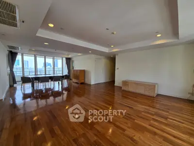 Spacious living room with wooden flooring and city view, perfect for modern living.