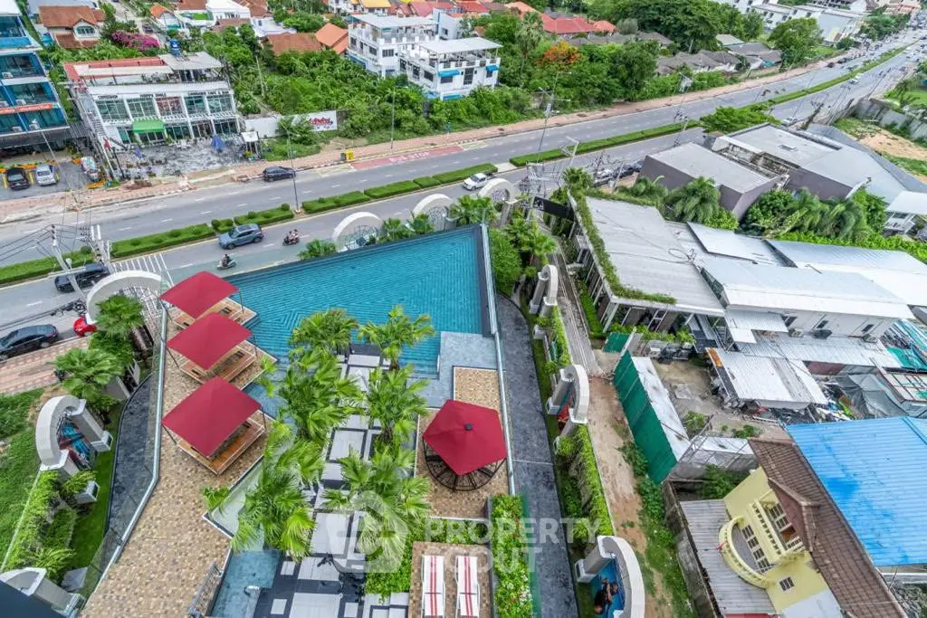Stunning aerial view of a luxurious rooftop pool with lush greenery and cityscape backdrop.