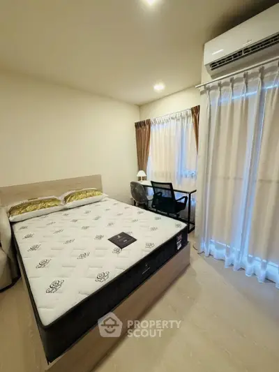 Modern bedroom with large window and air conditioning, featuring a comfortable bed and stylish decor.