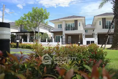 Modern suburban homes with lush landscaping and clear blue sky.