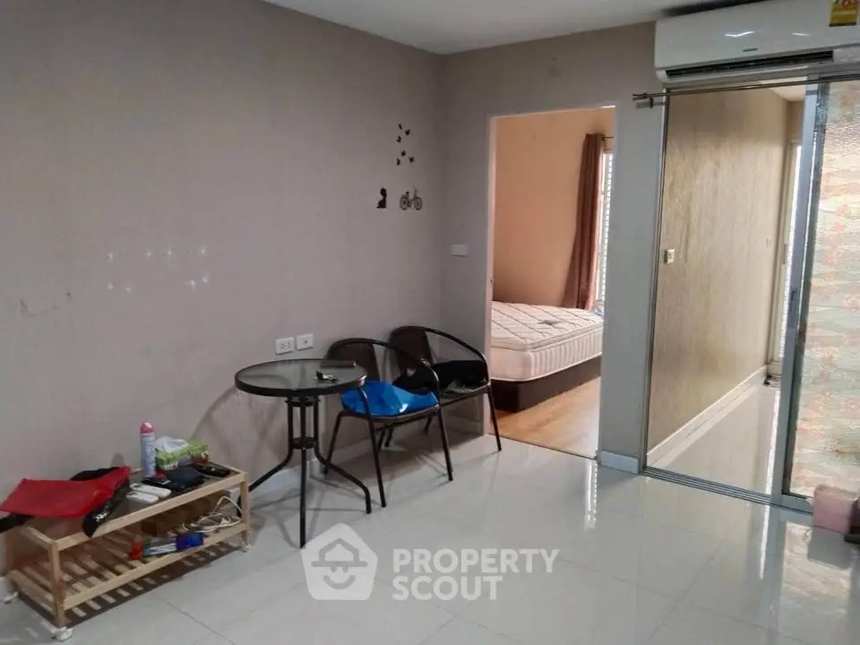 Cozy apartment interior with living area and bedroom, featuring modern furniture and air conditioning.