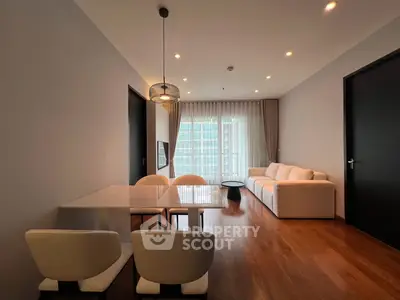 Modern living room with elegant dining area and large windows in a stylish apartment.