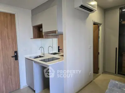 Modern compact kitchen with sleek cabinetry and dual sinks in a cozy apartment setting.
