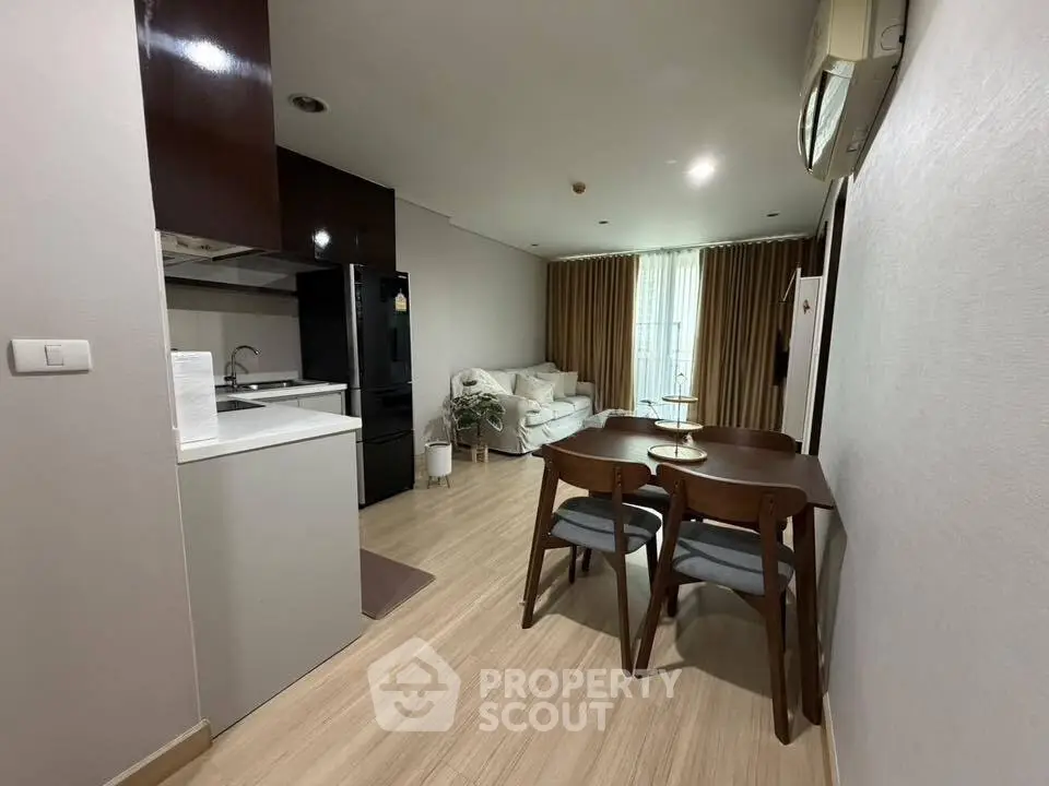 Modern open-plan living and dining area with sleek kitchen and cozy seating.