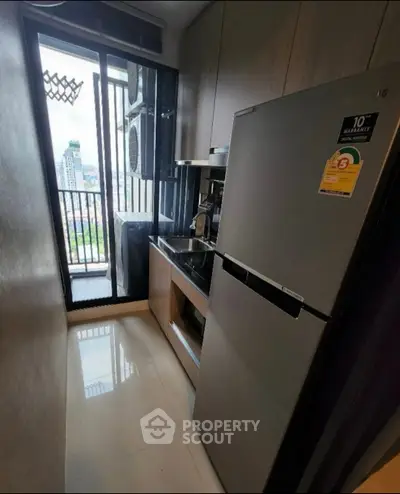 Compact kitchen with modern appliances and city view from window.
