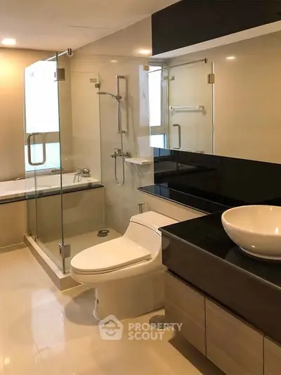 Modern bathroom with glass shower and sleek fixtures in a luxury apartment.
