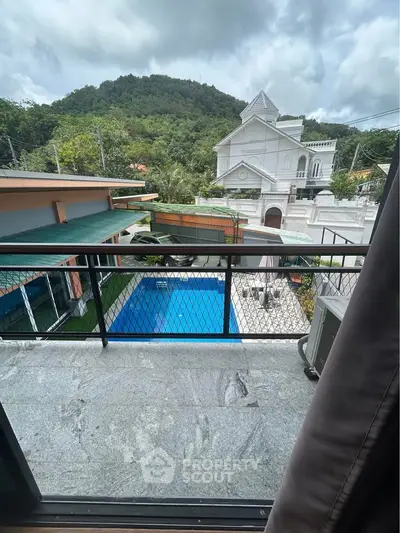 Stunning balcony view overlooking a private pool and lush green hills, perfect for relaxation and leisure.