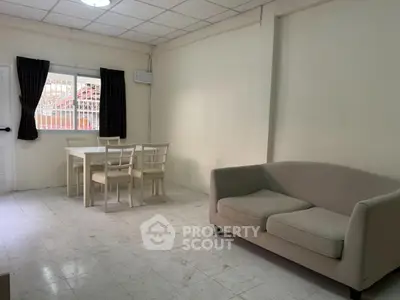Spacious living room with cozy sofa and dining area in a bright, minimalist design.