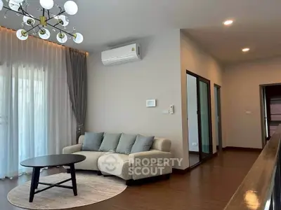 Modern living room with elegant chandelier and cozy sofa in a stylish apartment.