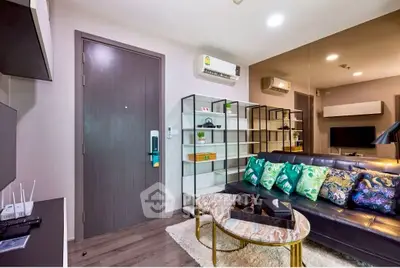 Modern living room with stylish decor and air conditioning, featuring a sleek sofa and elegant coffee table.