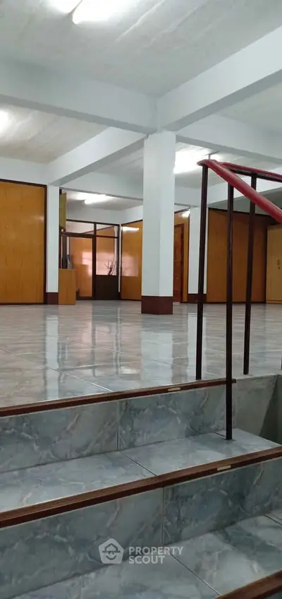 Spacious interior with polished floors and wooden accents, ideal for versatile real estate opportunities.