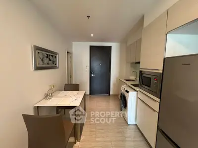 Modern kitchen with sleek appliances and dining area in a stylish apartment.