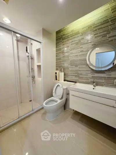Modern bathroom with sleek shower and stylish vanity in contemporary apartment.