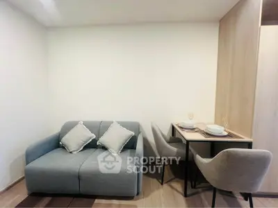 Cozy modern living room with stylish sofa and dining area in compact apartment.
