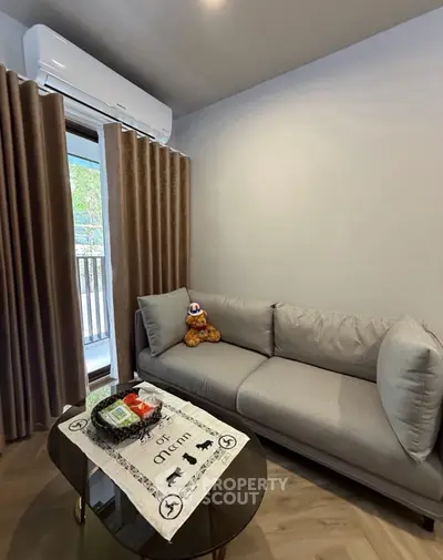 Cozy living room with modern sofa and air conditioning, perfect for relaxation.