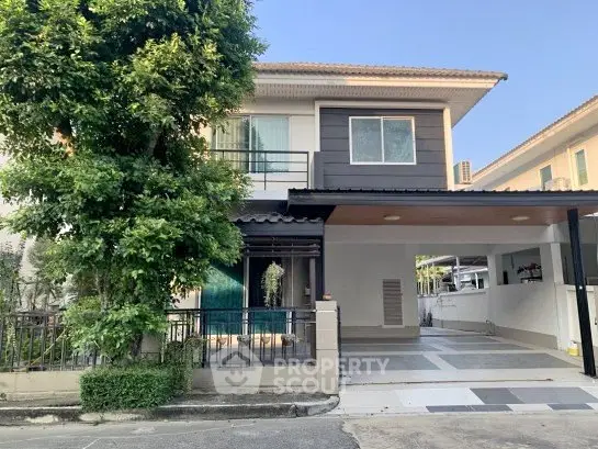 Charming two-story house with spacious driveway and lush greenery in a serene neighborhood.