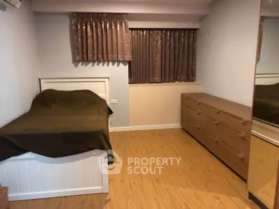 Cozy bedroom with wooden flooring and ample storage space
