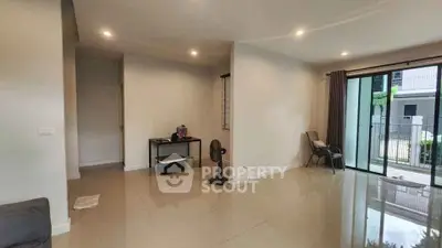 Spacious living room with glossy tile flooring and large sliding glass doors leading to a balcony.