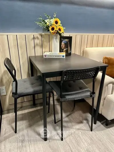 Chic small dining area with modern table, chairs, and floral decor in cozy interior setting.