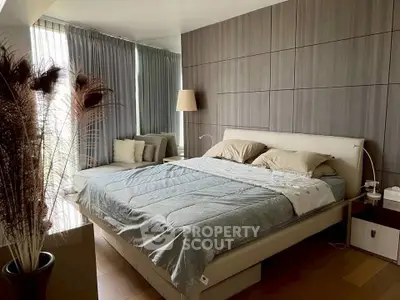 Luxurious modern bedroom with elegant decor and cozy seating area, perfect for relaxation.