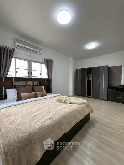 Spacious modern bedroom with stylish decor and ample natural light