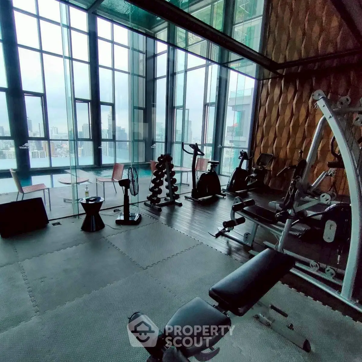 Luxurious high-rise gym with panoramic city views and modern fitness equipment.