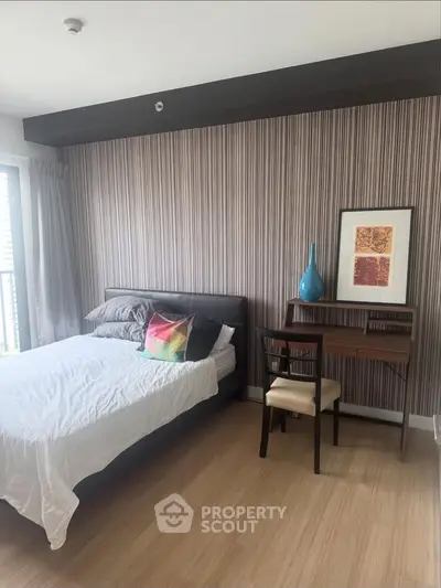 Modern bedroom with stylish decor and natural light, featuring a cozy bed and a sleek desk for work or study.