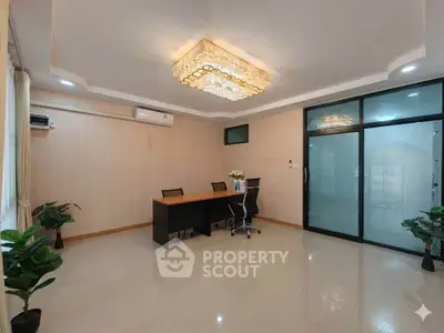 Spacious office room with elegant chandelier and modern glass partition