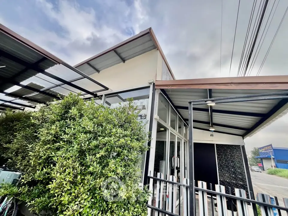 Modern building exterior with sleek design and lush greenery, showcasing contemporary architecture.